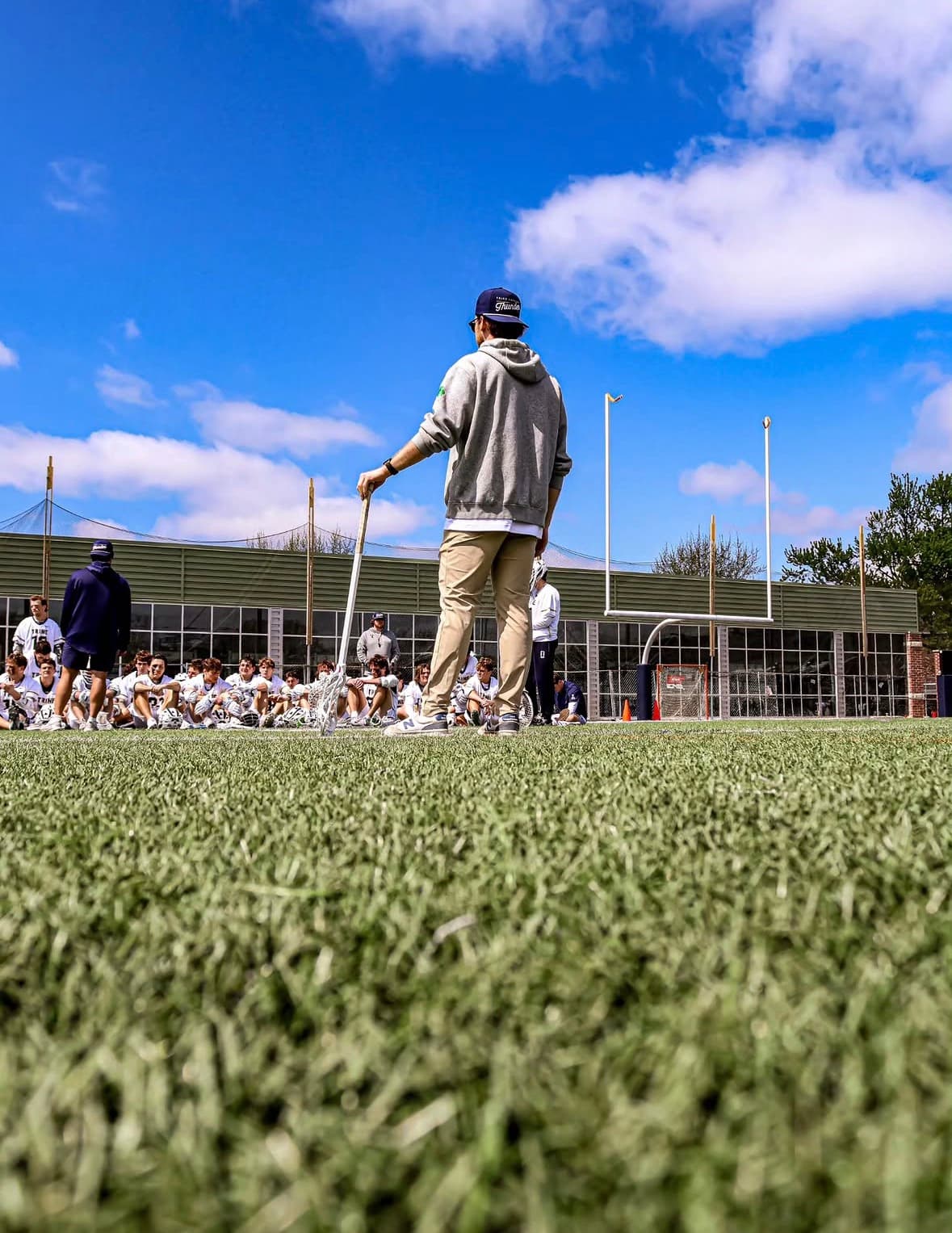 Coach addressing players on a lacrosse field